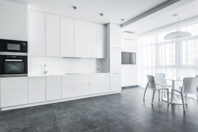 Large-format grey tile flooring in a bright white Oregon kitchen, the grout grid running the length of the room