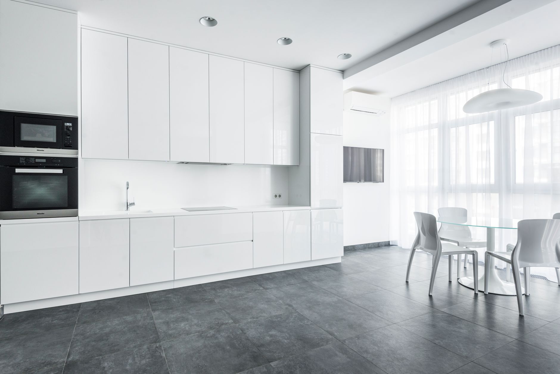 Large-format grey tile flooring in a bright white Oregon kitchen, the grout grid running the length of the room