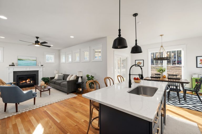 Oak hardwood flooring running through an open Oregon living room to a fireplace and the kitchen island
