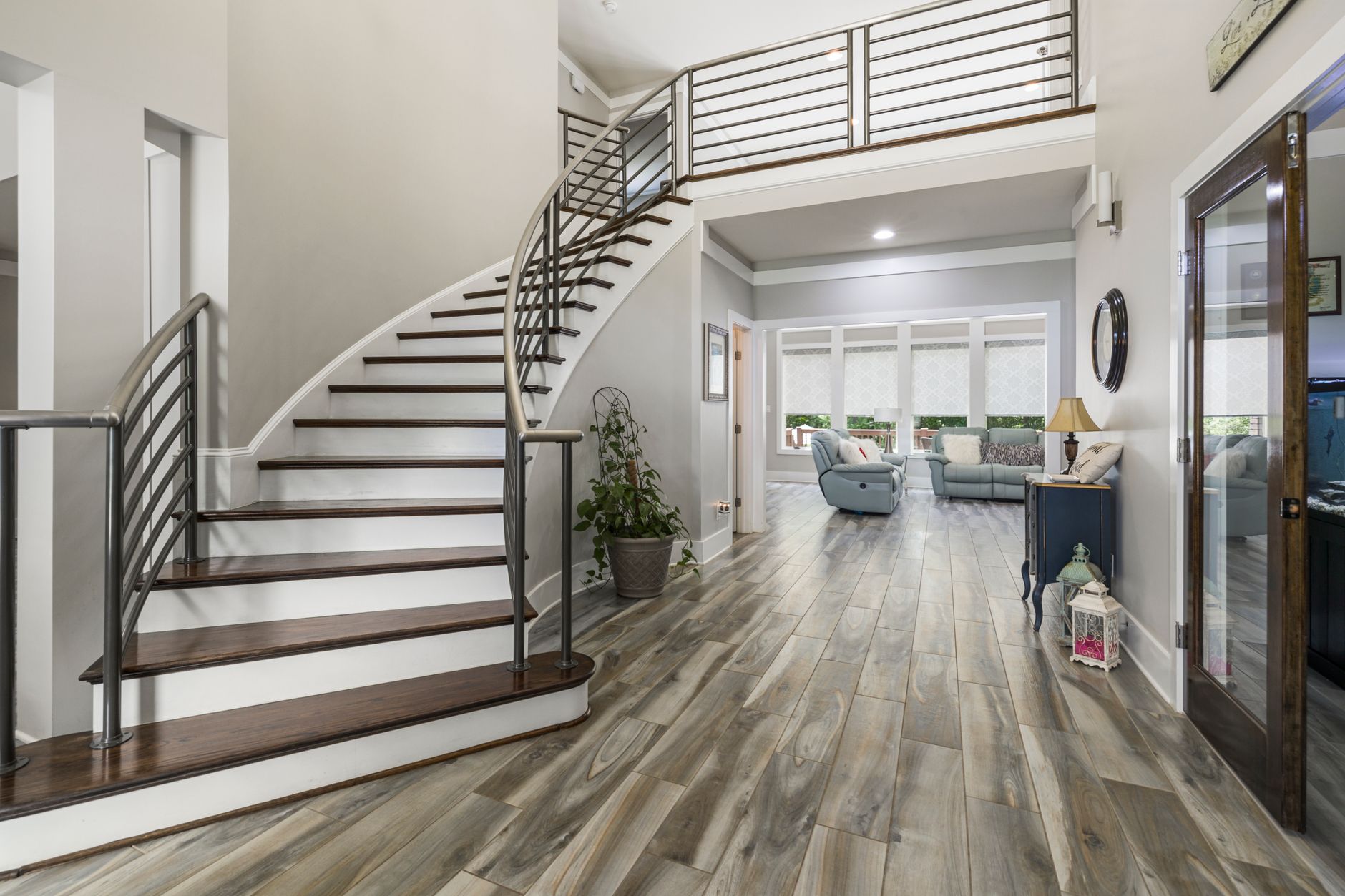 Spacious modern home interior featuring a curved staircase and stylish decor